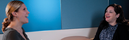 Image of a female client and female therapist laughing together. Image of a female client and female therapist laughing together.