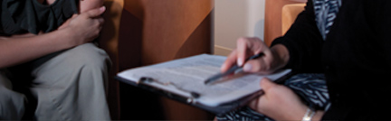 Image of hands writing on a clipboard Image of hands writing on a clipboard