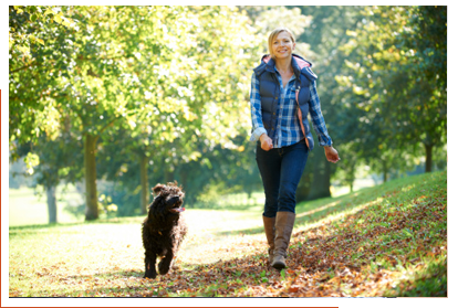 Woman walking with dog in park