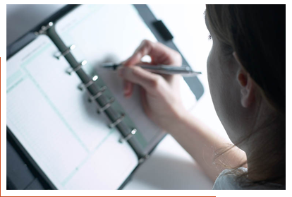 Woman sitting at desk writing in a notebook