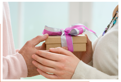 Hands of a man and woman holding a gift box between them