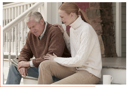 Man and woman sitting on steps in front of a house