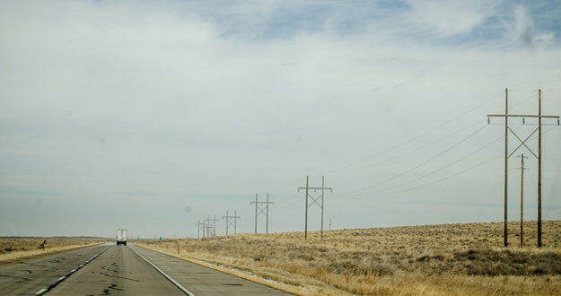 Country highway surrounded by fields after harvest