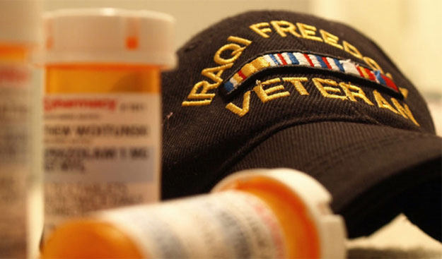 Iraq Veteran cap sitting next to prescription pill bottles